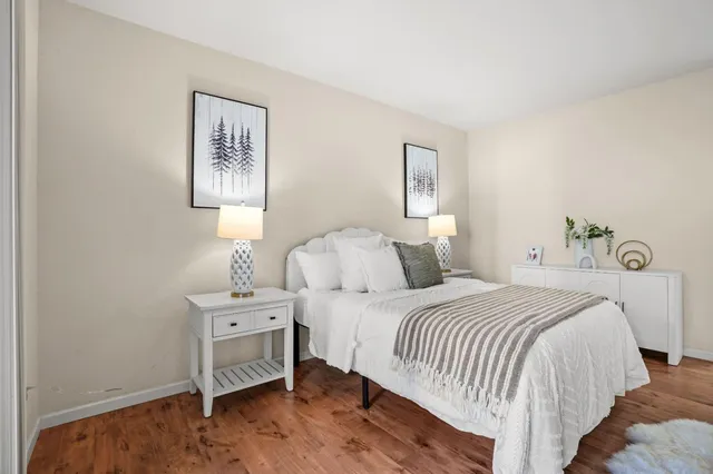 a bedroom with a bed and painting on the wall