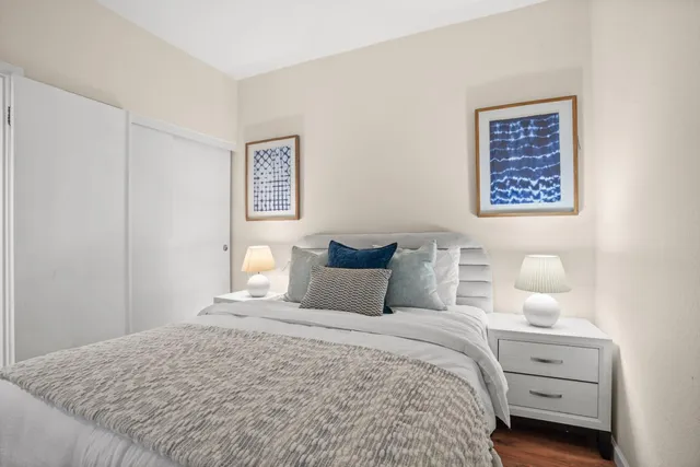 a bedroom with a bed and painting on the wall