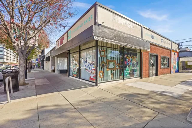 a street sign on a sidewalk next to a building