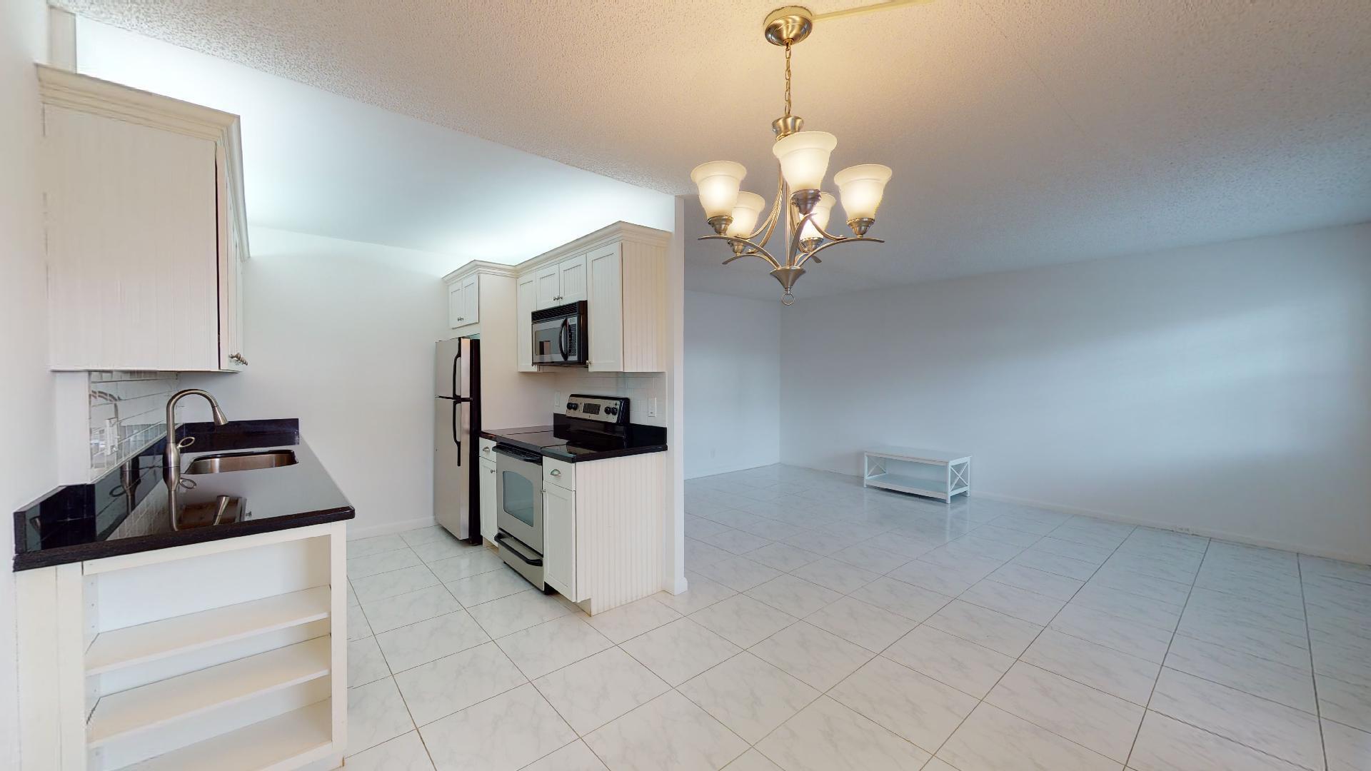 1014 Exeter Boca Raton, FL 33434 - Photo 8 of 31 a kitchen that has a sink stainless steel appliances and cabinets