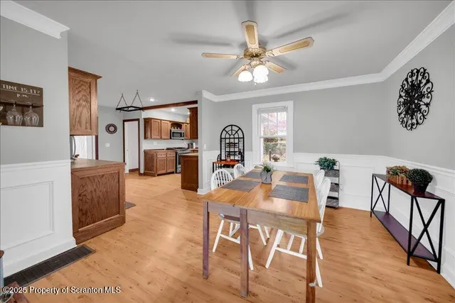 a view of a dining room with furniture a chandelier and wooden floor