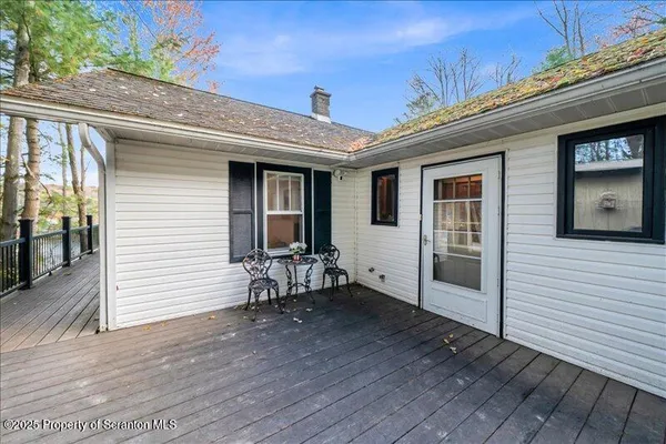 a view of a patio with table and chairs with wooden floor and fence