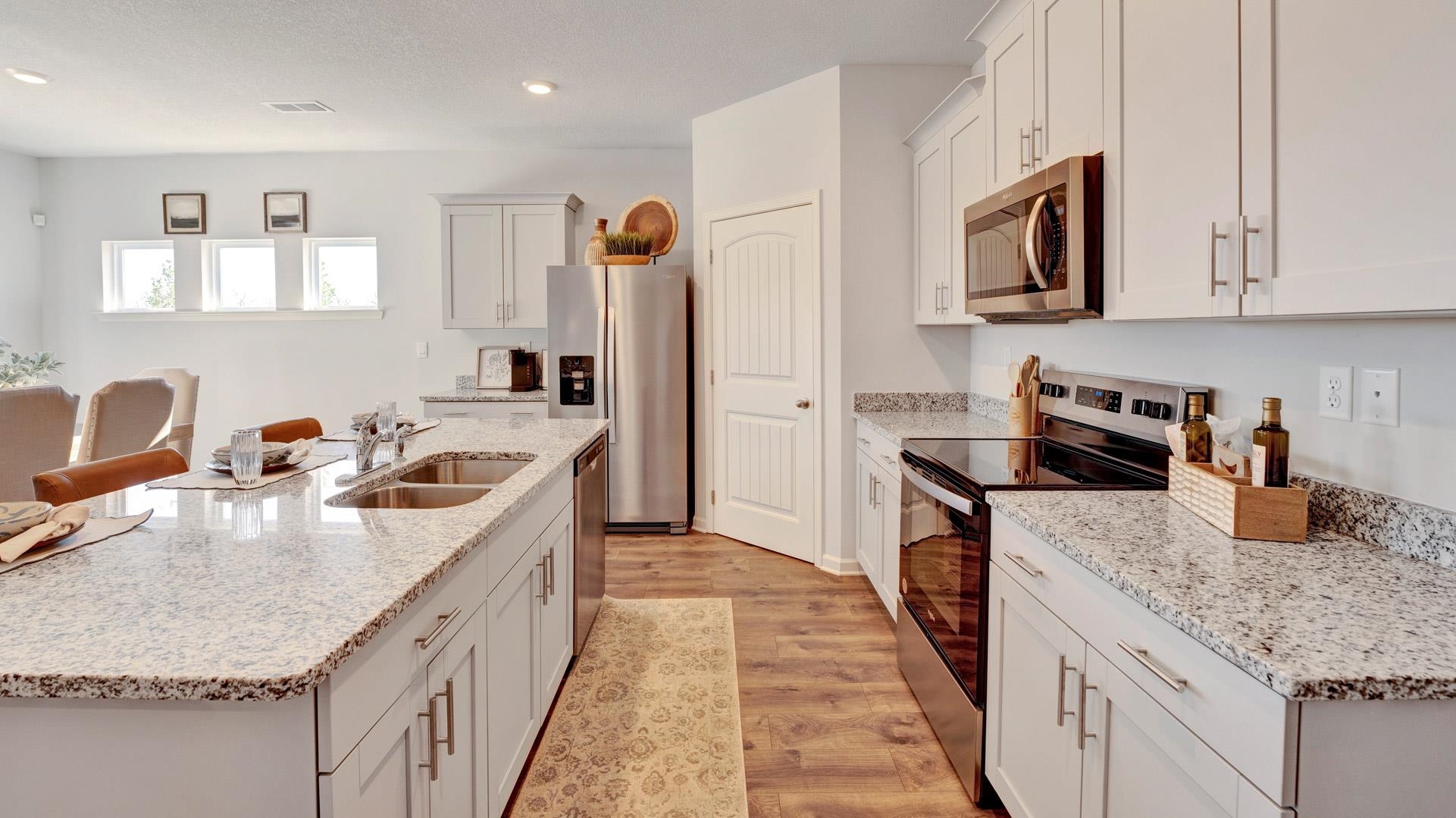 1020 Mewborn Farm Road Oakland, TN 38060 - Photo 7 of 36 Kitchen with stainless steel appliances, light wood-style floors, light stone counters, an island with sink, and recessed lighting