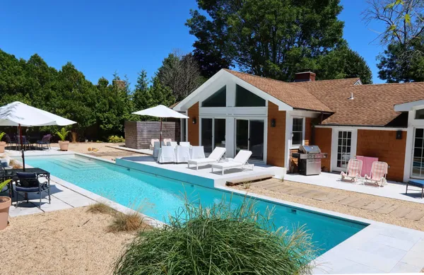 a house view with swimming pool and garden space