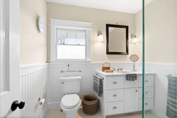 a bathroom with a granite countertop toilet sink and mirror