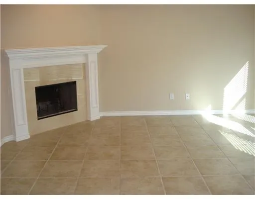 a view of an empty room with a fireplace and a window