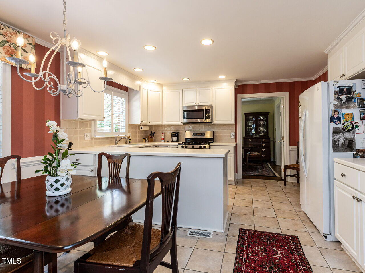 3209 Northampton Street Raleigh, NC 27609 - Photo 17 of 31 a kitchen with stainless steel appliances kitchen island granite countertop a sink a stove a table and chairs