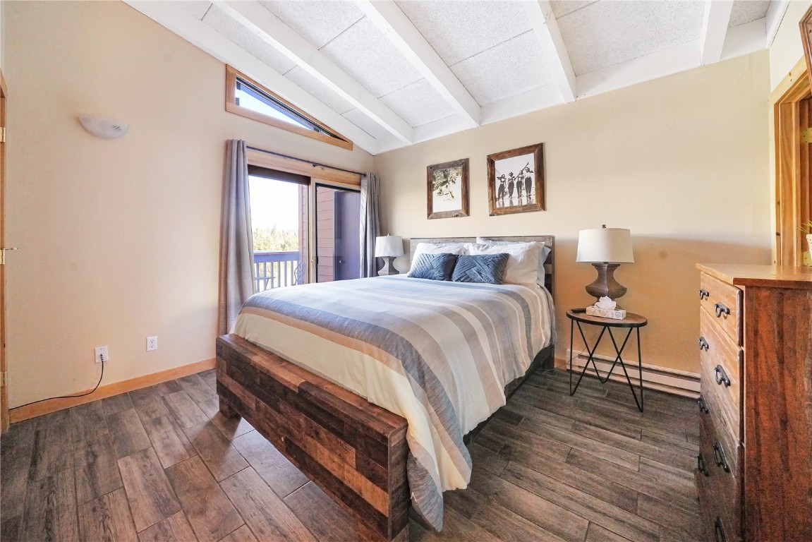 1513 East Keystone Road, Unit 2972 Keystone, CO 80435 - Photo 11 of 36 Bedroom featuring lofted ceiling with beams, a baseboard radiator, access to outside, and dark hardwood / wood-style flooring