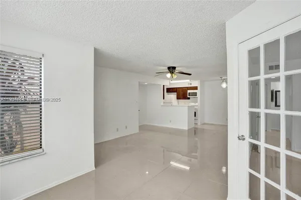 a view of a kitchen with white cabinets and stainless steel appliances