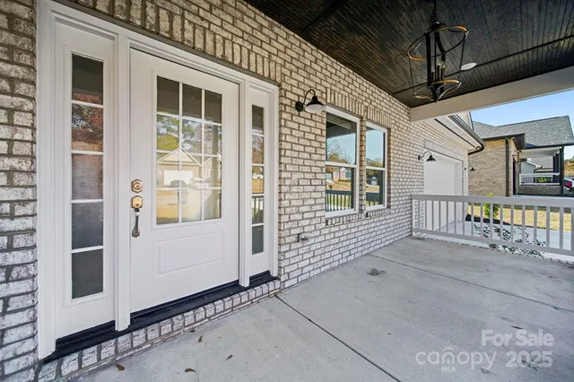 an empty room with wooden floor chandelier fan and windows