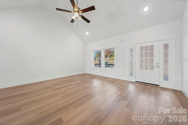 a view of empty room with wooden floor and window
