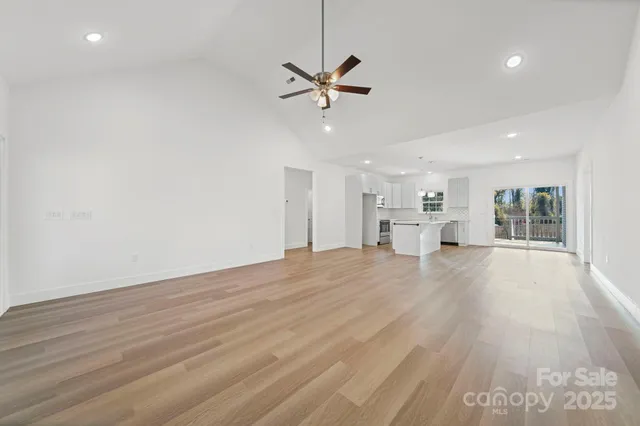 a view of a kitchen with a sink and dishwasher a refrigerator with wooden floor