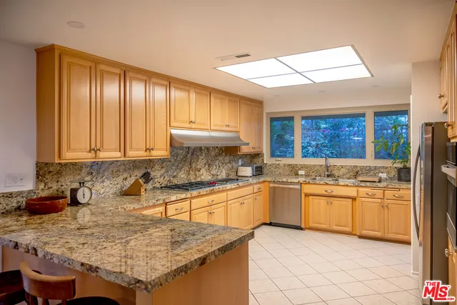 a kitchen with stainless steel appliances granite countertop a sink stove and cabinets