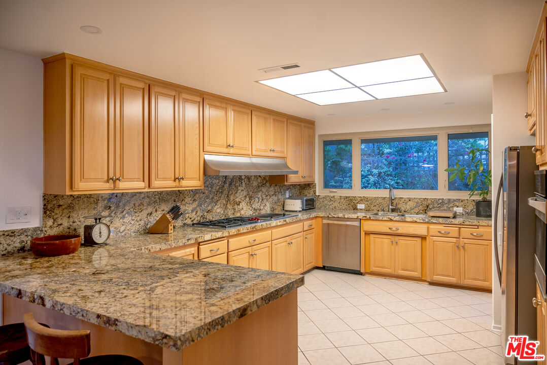 2701 Lake Hollywood Drive Los Angeles, CA 90068 - Photo 16 of 41 a kitchen with stainless steel appliances granite countertop a sink stove and cabinets