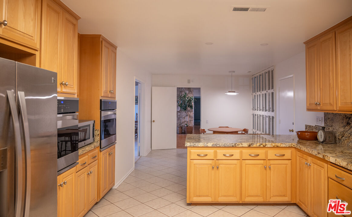 2701 Lake Hollywood Drive Los Angeles, CA 90068 - Photo 17 of 41 a kitchen with stainless steel appliances granite countertop a sink refrigerator and cabinets