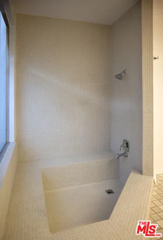 a bathroom with a bathtub and shower