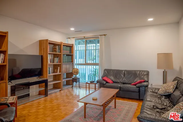 a living room with furniture a rug and a flat screen tv