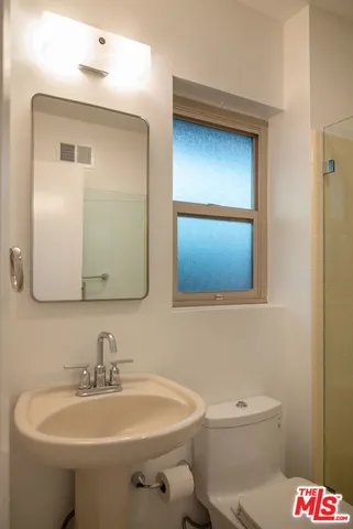 a bathroom with a toilet sink and mirror