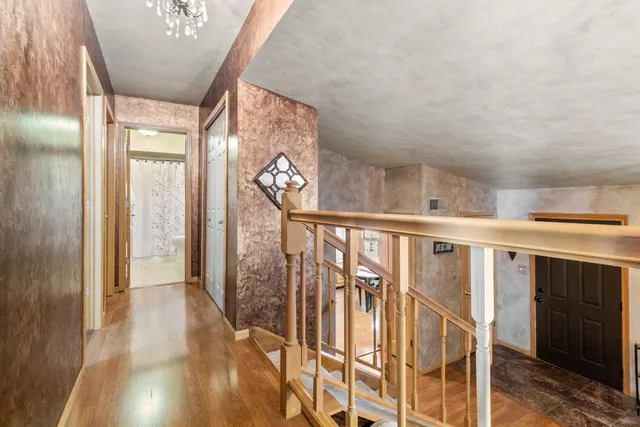 a view of a hallway with wooden floor and staircase