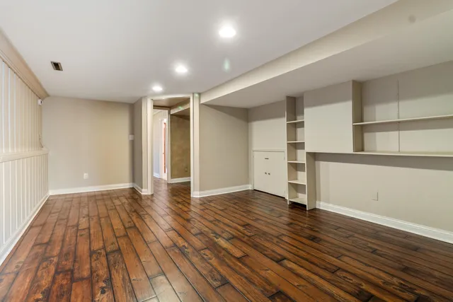a view of an empty room with wooden floor