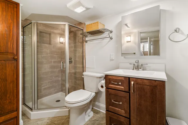 a bathroom with a sink a toilet and shower