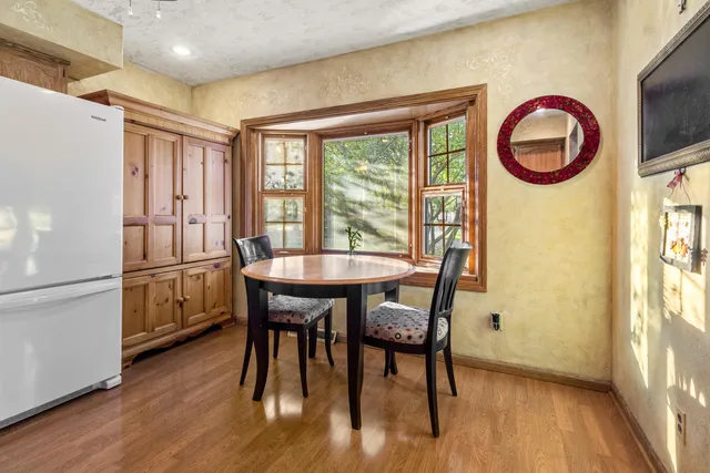 a kitchen with a table chairs refrigerator and cabinets