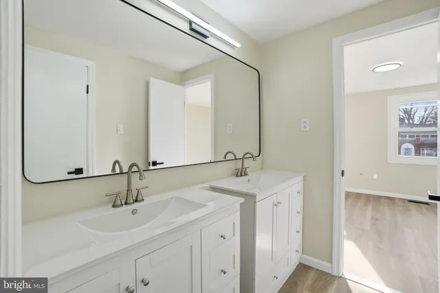 a bathroom with 2 sink and a mirror