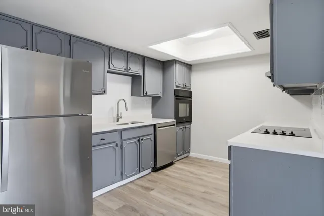 a kitchen with stainless steel appliances granite countertop a refrigerator sink and stove