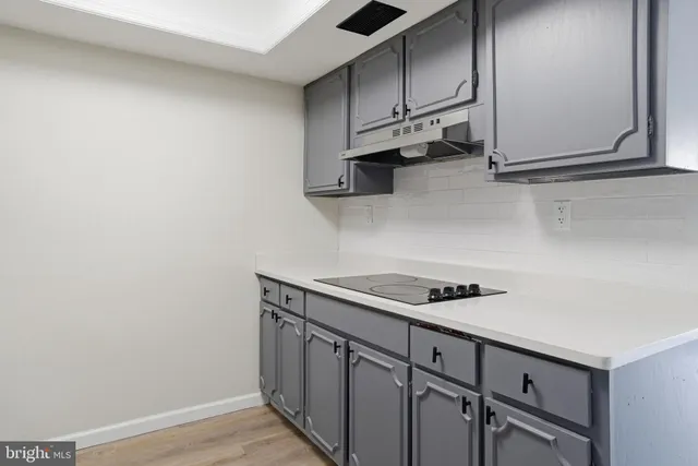 a kitchen with stainless steel appliances a sink cabinets and wooden floor