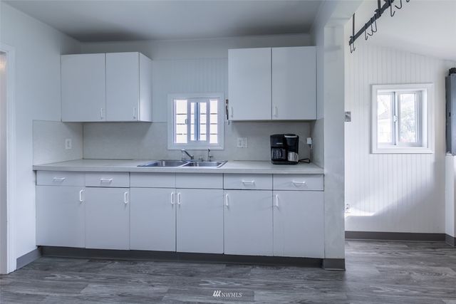 a kitchen with a white stove top oven and white cabinets