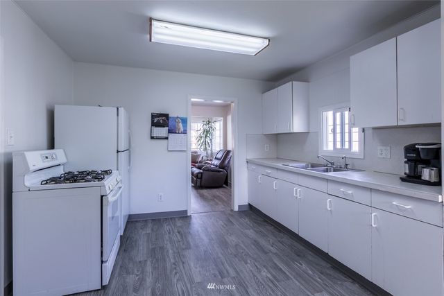 a large kitchen with a lot of counter space and wooden floor