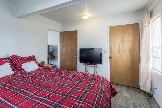 a bedroom with a bed and wooden floor