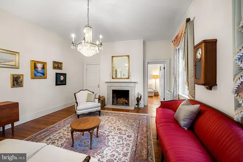 a living room with furniture a fireplace and a chandelier