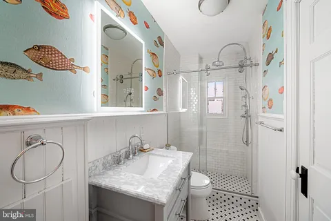 a bathroom with a granite countertop sink toilet and shower