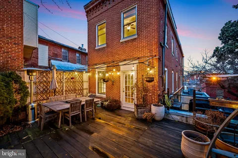 a view of a patio with table and chairs with wooden floor and fence
