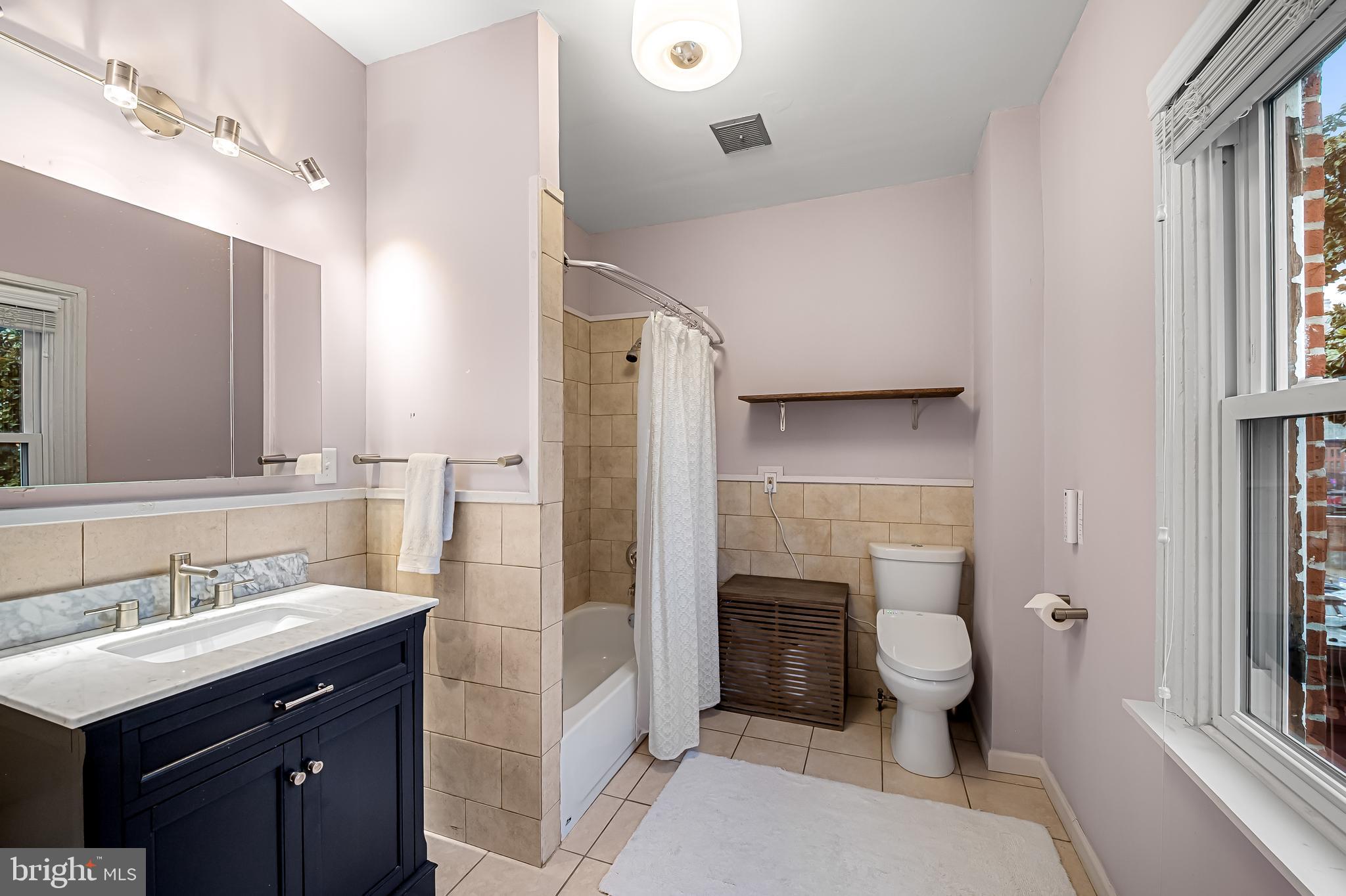 16 West Read Street Baltimore, MD 21201 - Photo 34 of 59 a bathroom with a sink toilet a mirror and shower