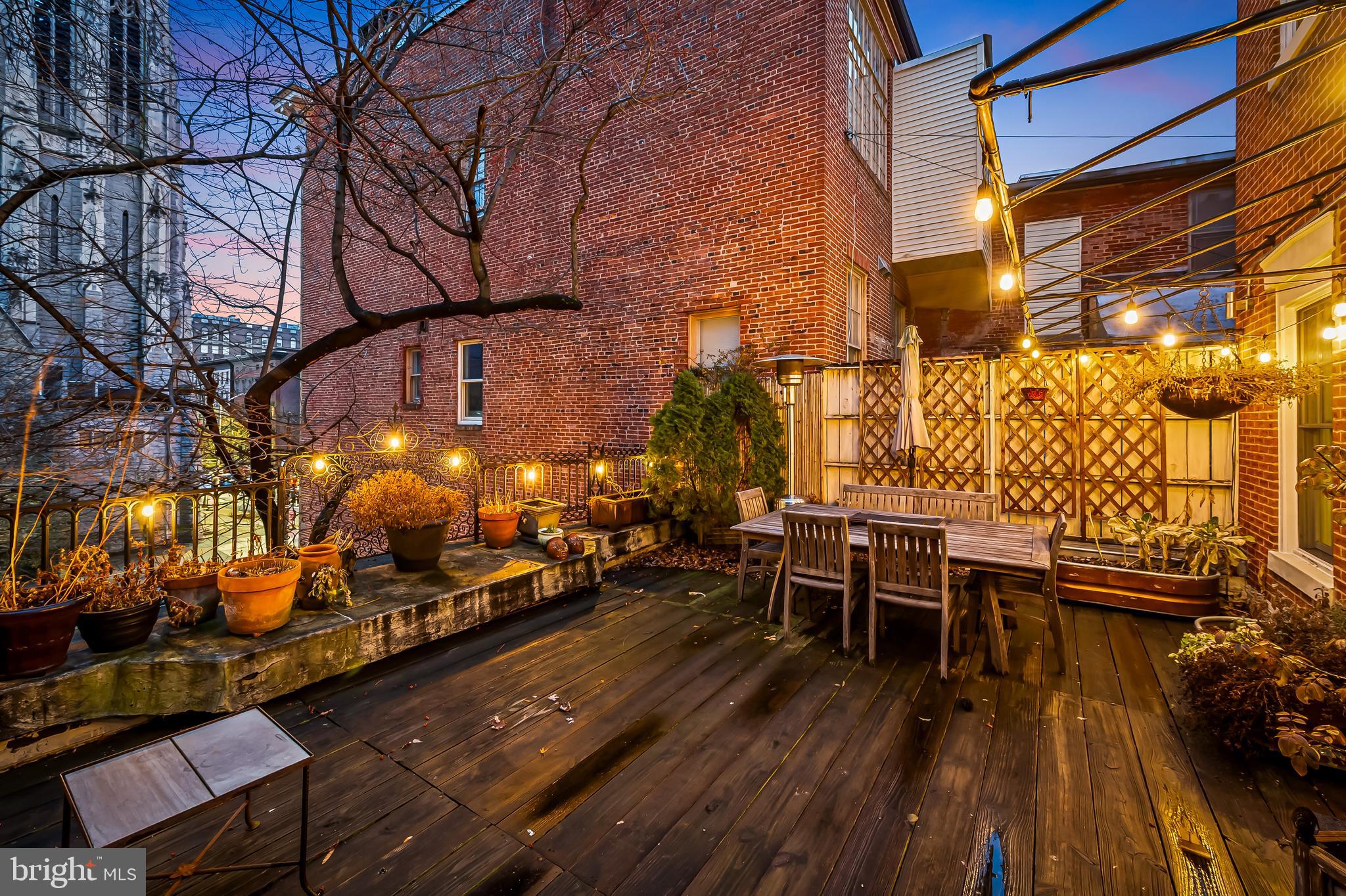 16 West Read Street Baltimore, MD 21201 - Photo 4 of 59 a view of a patio with table and chairs with wooden floor and fence