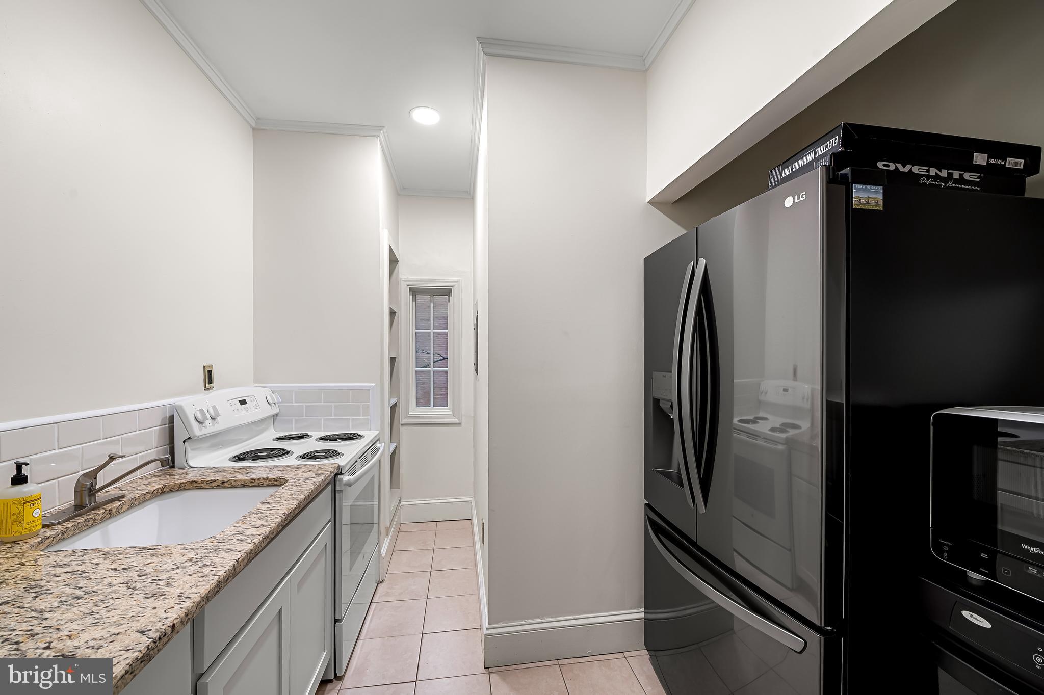 16 West Read Street Baltimore, MD 21201 - Photo 8 of 59 a kitchen with granite countertop a refrigerator stove and sink