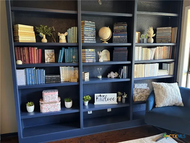 a view of living room with furniture and book shelf
