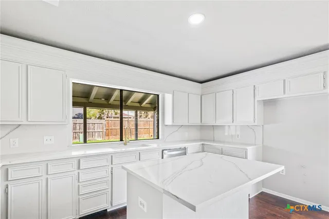 a kitchen with a sink cabinets and window