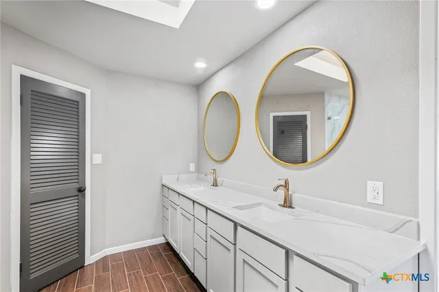 a bathroom with a double vanity sink and a mirror