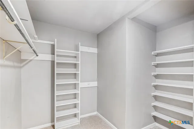 a view of walk in closet with empty racks