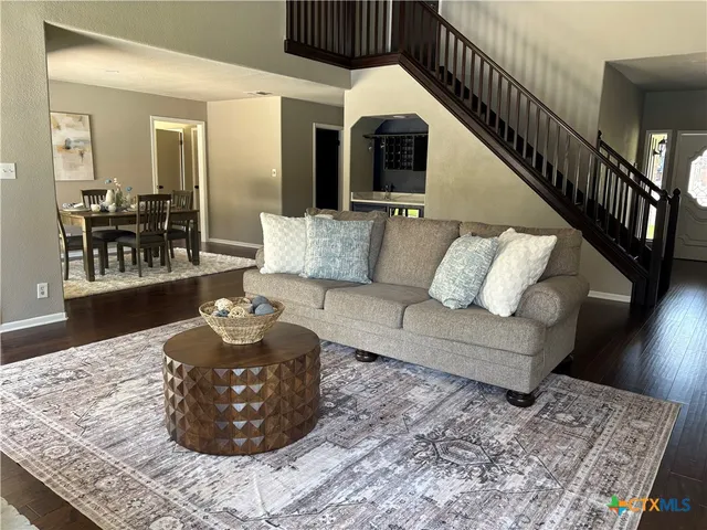 a living room with furniture and wooden floor
