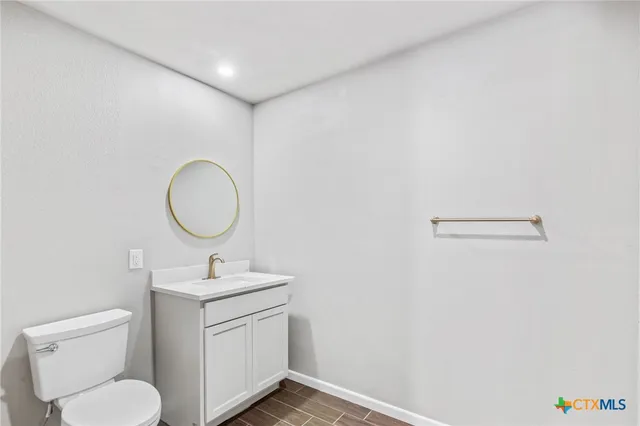 a bathroom with a toilet a sink and a mirror