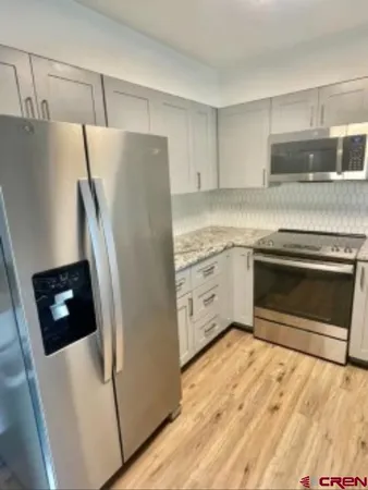 a kitchen with stainless steel appliances a stove a refrigerator and a sink