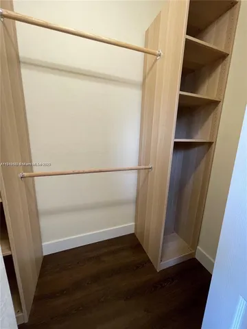 a view of walk in closet with wooden floor