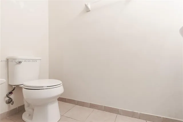 a white toilet sitting next to a white wall