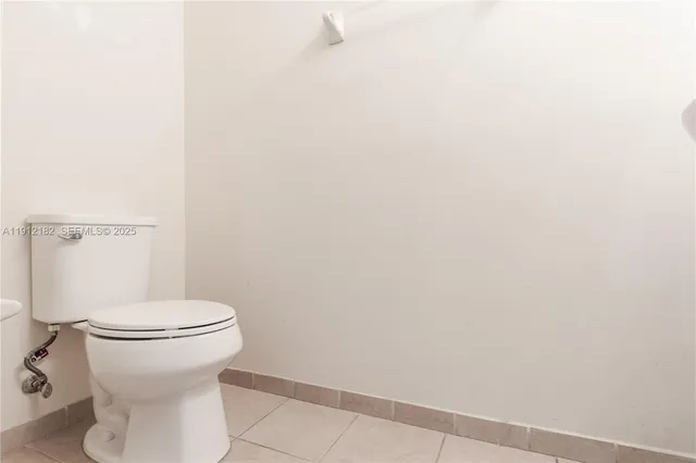 a white toilet sitting next to a white wall