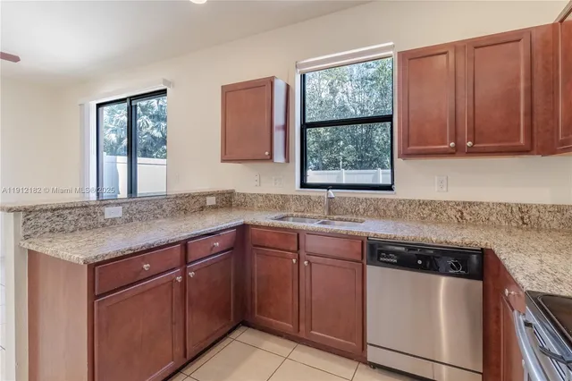 a kitchen with a sink cabinets window and a refrigerator