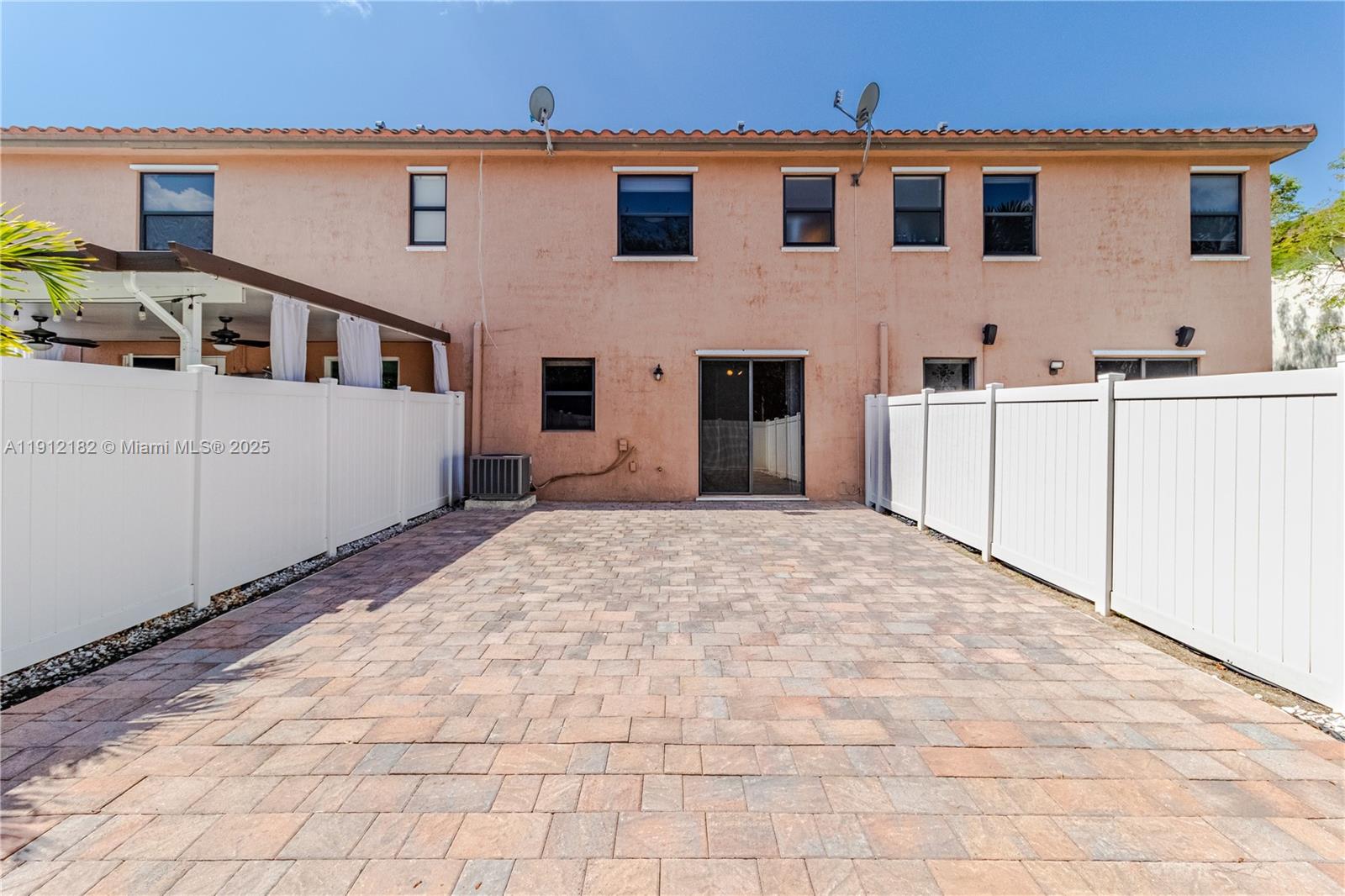 9045 West 33rd Avenue, Unit 9045 Hialeah, FL 33018 - Photo 10 of 23 a view of a white house with wooden fence